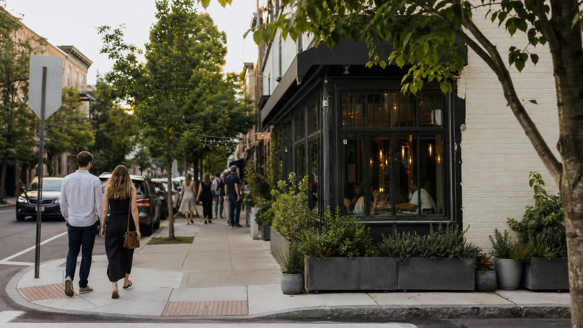Neighborhood restaurant street approach with sidewalk pedestrians in late-afternoon light — local SEO and near-me discovery